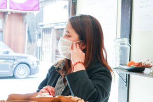 こめかみに手を当てて取引先さんと話す赤木有真（美観堂）