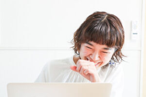 口に手を当てて笑う久保千聡（パソコン前）